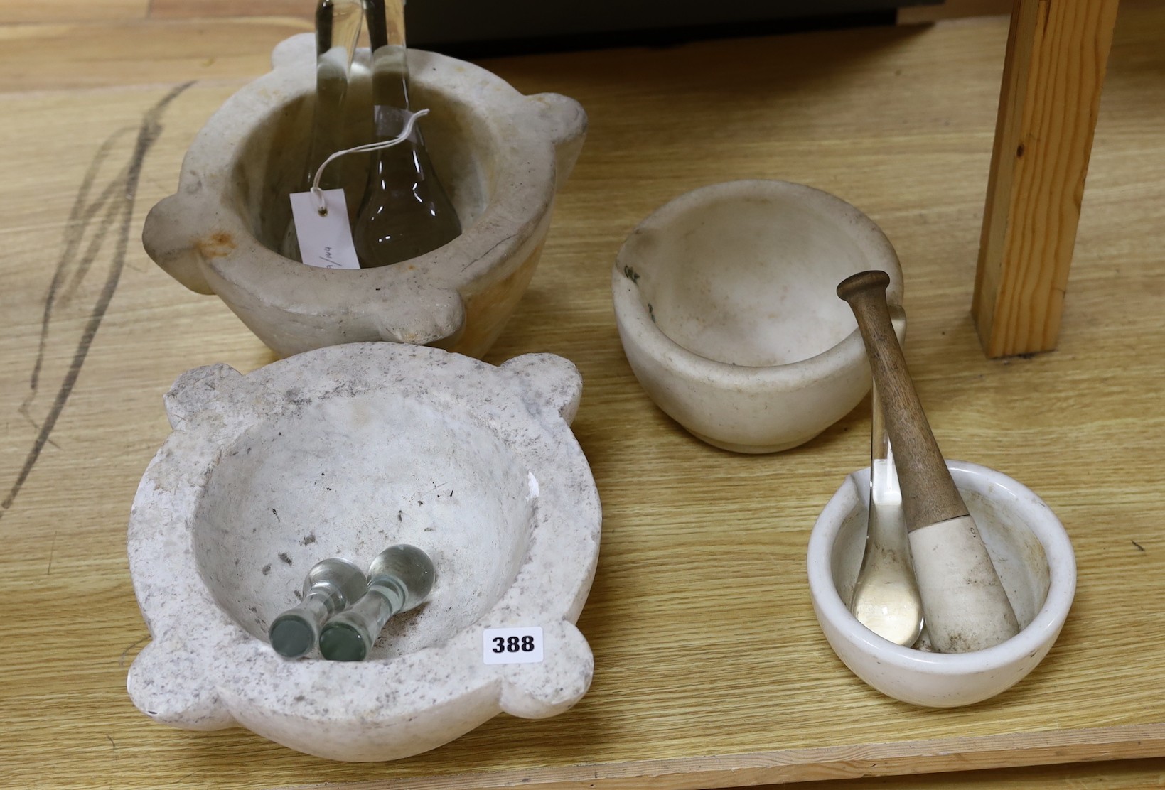 A collection of white marble and other mortars together with glass and other pestles (qty), largest 32 cms wide